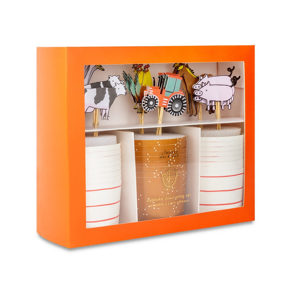 Orange‑framed window box showing farm animal cupcake kit with cups and assorted toppers.