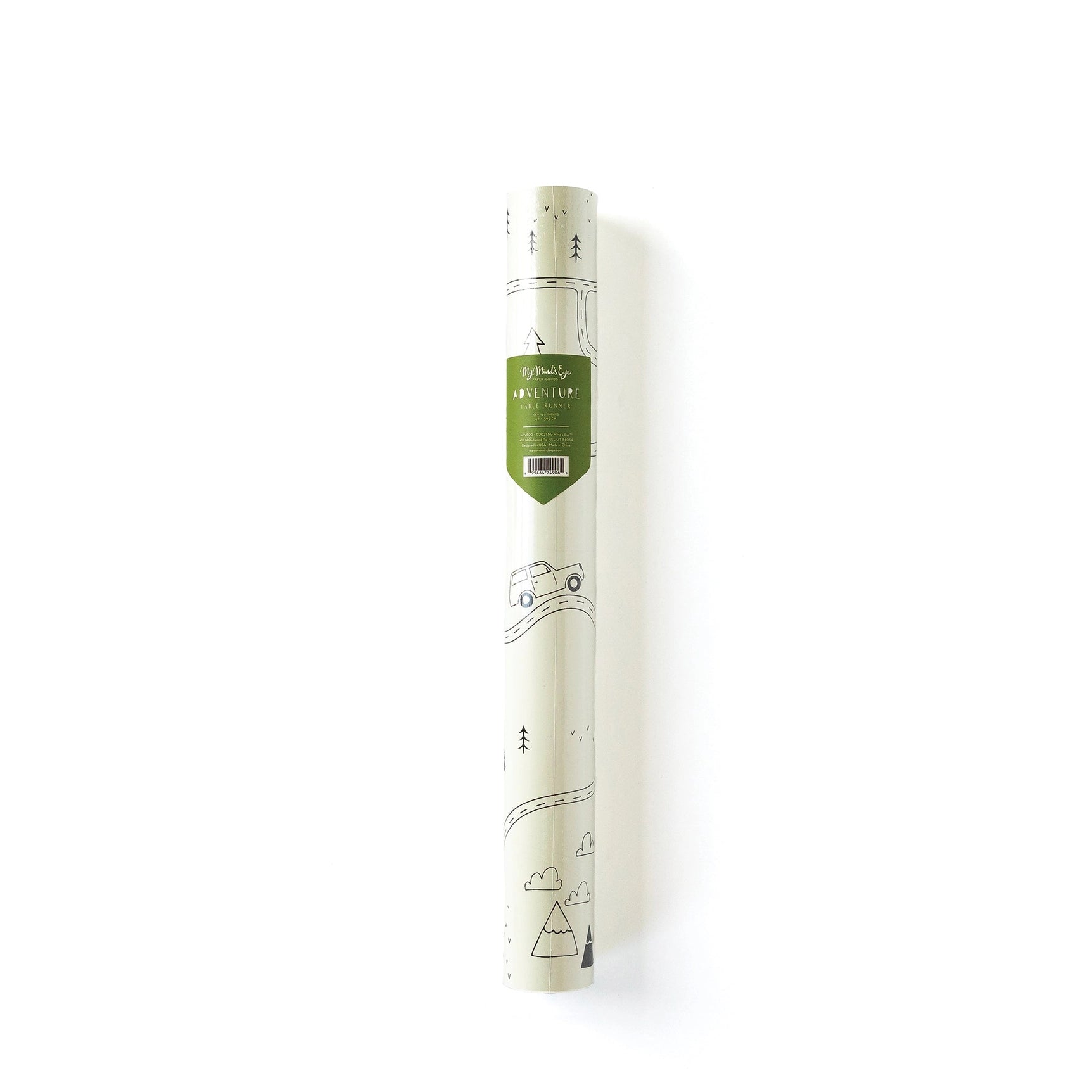 Adventure-themed paper table runner rolled in its packaging, with forest sketch peeking through and a green label showing dimensions and theme.