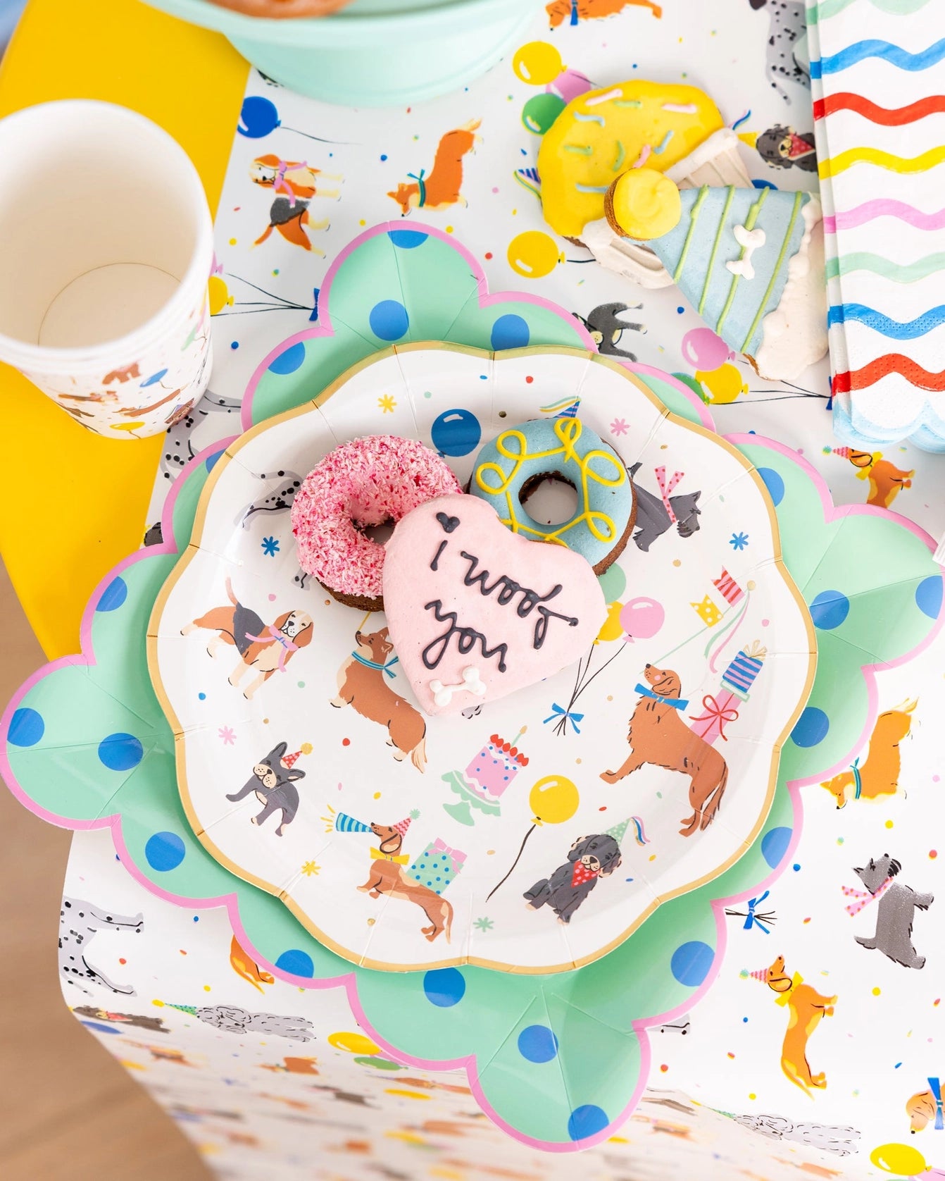 Layered table setting: mint polka dot plate under a dog-themed round plate topped with colorful treats.