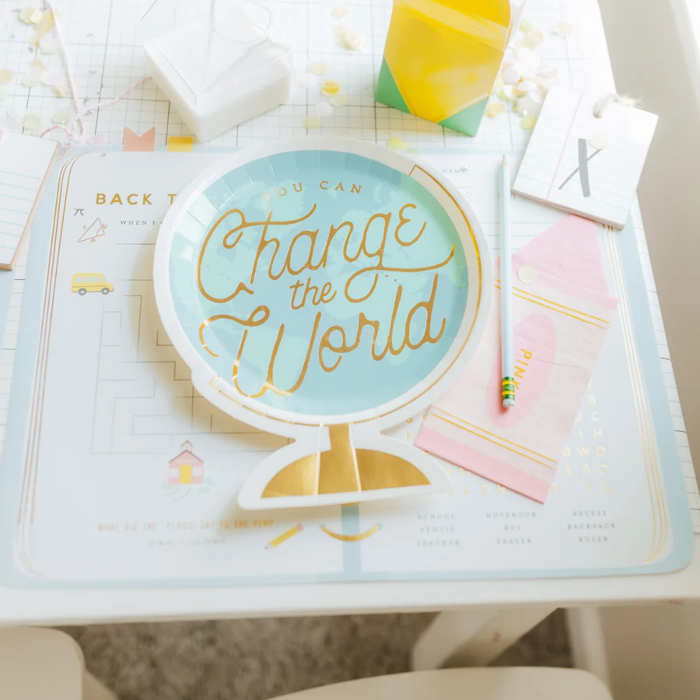 Decorated kids’ table with educational placemats and globe plate