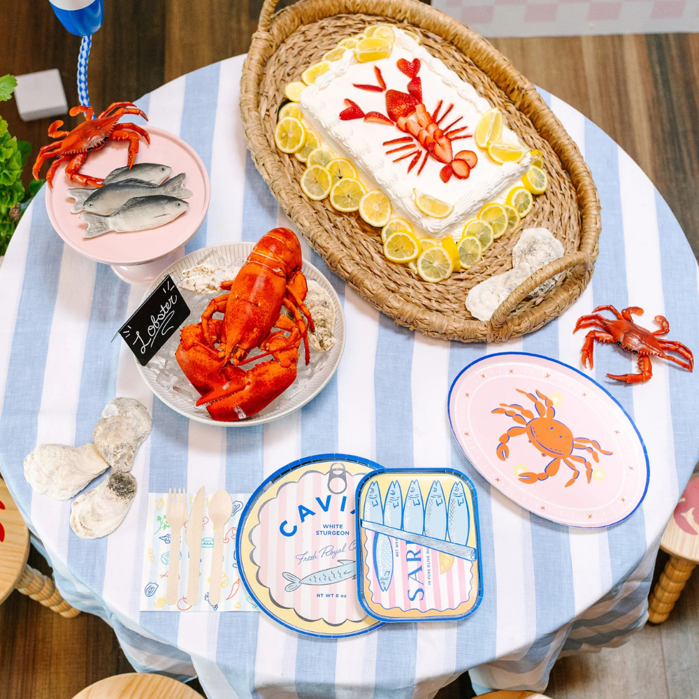 A set table featuring the Le Dinner Crab Platter Charger Plates with red crab design and citrus accents.