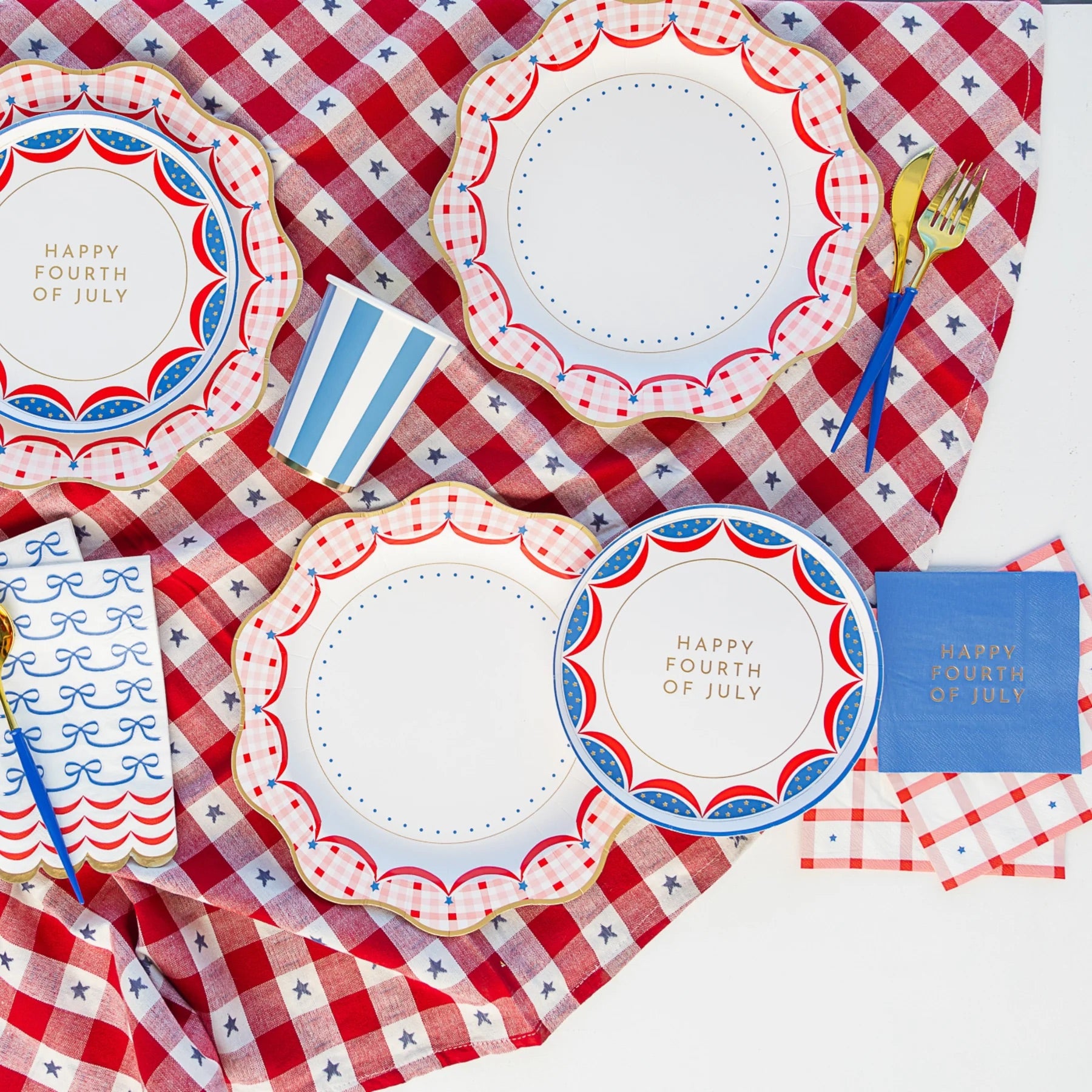 A set of patriotic guest towels styled on a red gingham tablecloth, surrounded by festive summer tableware, ready for a classic backyard BBQ or 4th of July picnic.