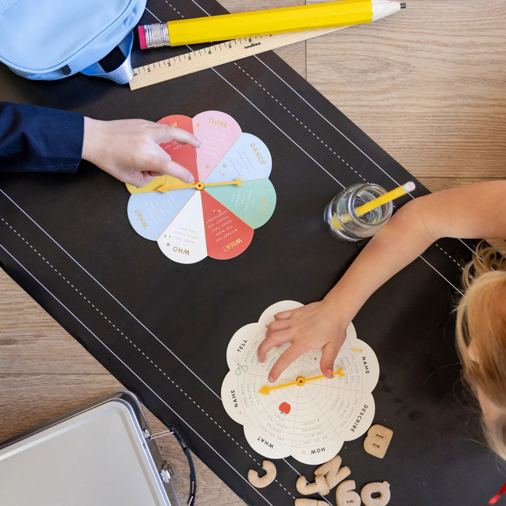 Two children playing with colorful and white spinner boards on table