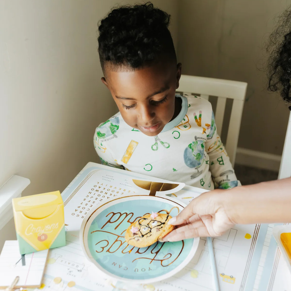 Close-up of a child eating cookies off the globe plate