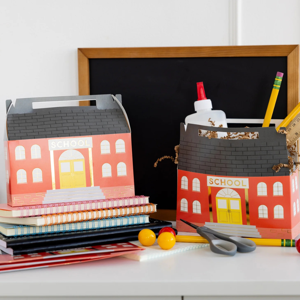 Two assembled treat boxes on a desk with school supplies in the background