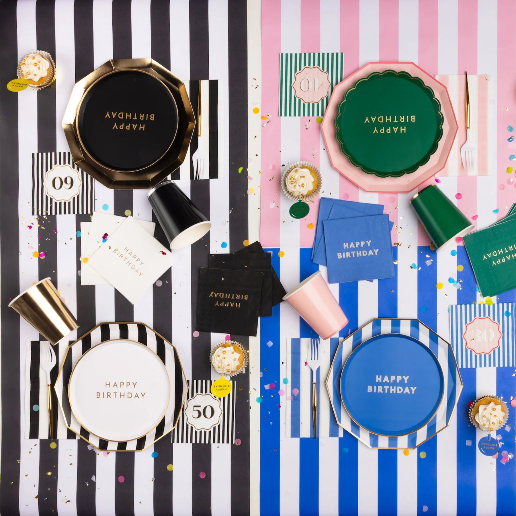 Overhead lifestyle shot of elegant black and white milestone birthday party table with Happy Birthday plates, black and white striped napkins, black cups and gold accents with confetti