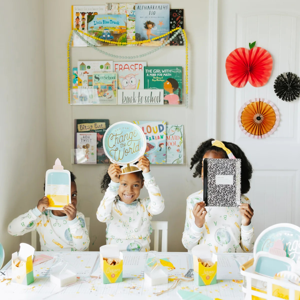 Three children holding themed paper plates during a school party