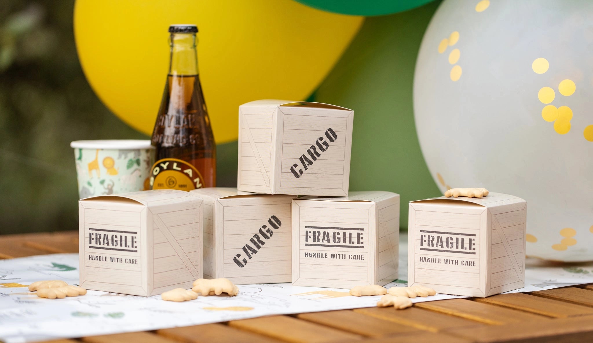 Detailed close-up of safari cargo-style treat boxes next to a cream soda and jungle-themed cups.