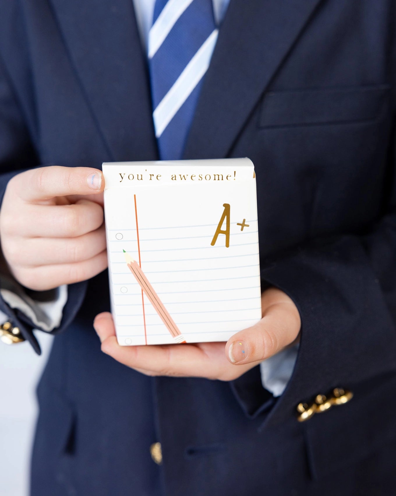 Close-up of a student holding one treat box, with “you’re awesome!” printed at the top flap.