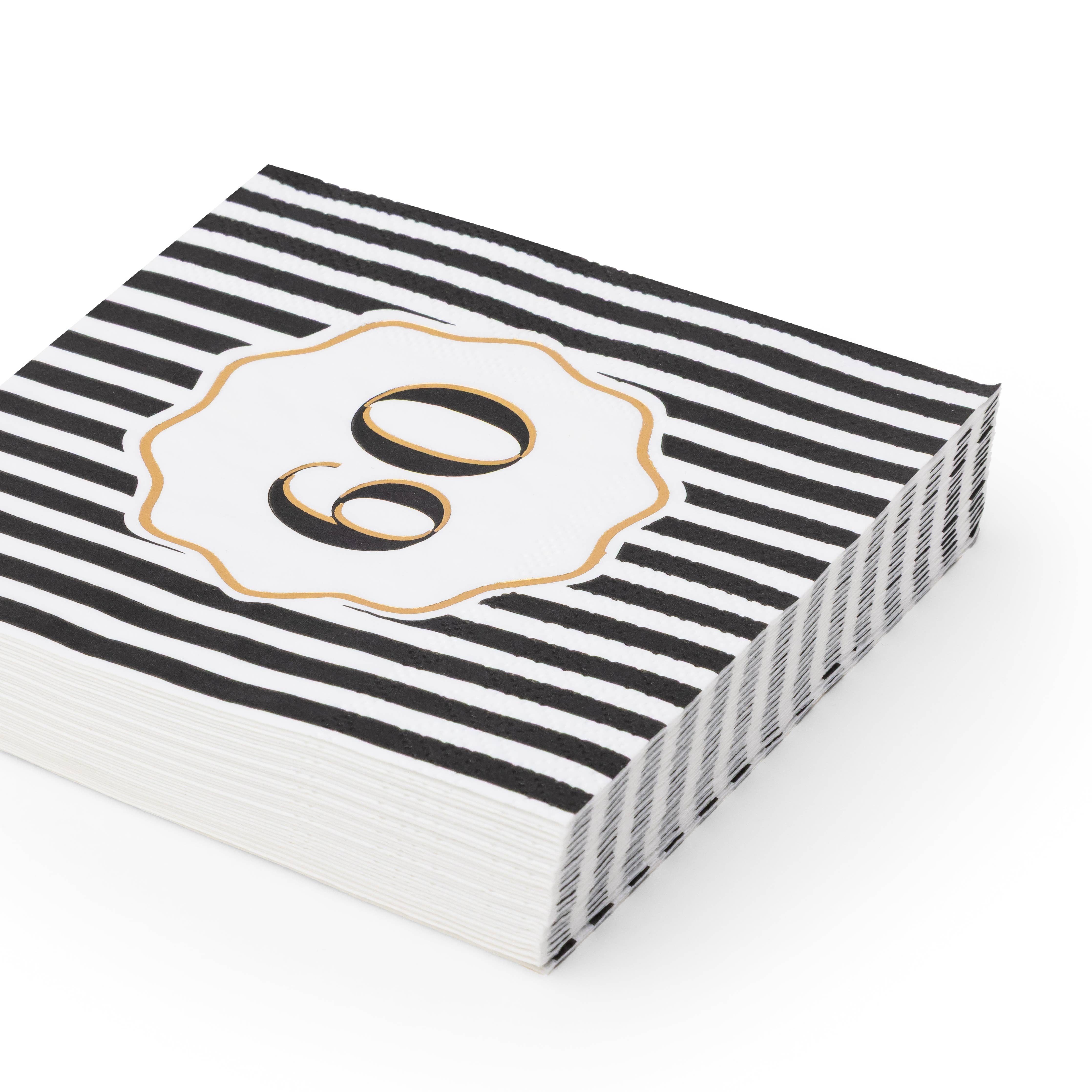Angled stack of black and white striped 60th birthday cocktail napkins with white gold rimmed number 60 scalloped medallion on white background
