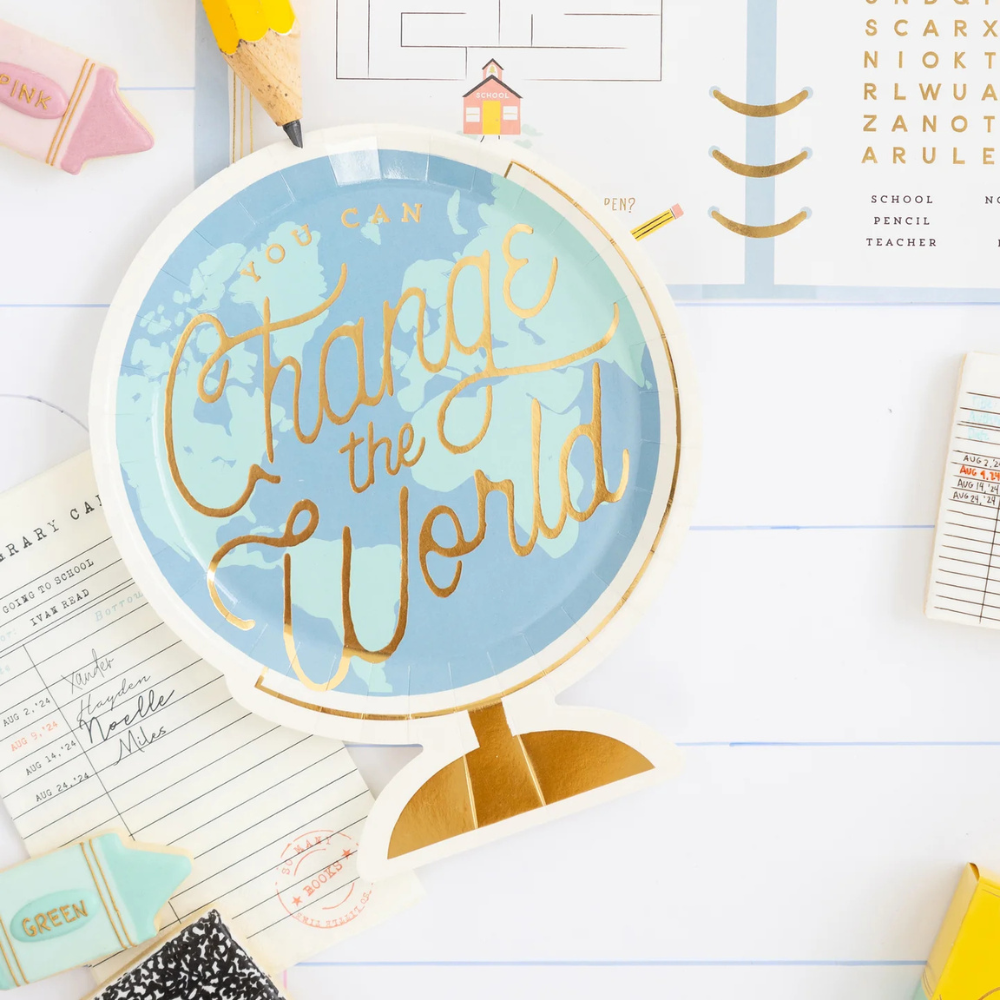 Styled desk flat lay with globe paper plate and school supplies