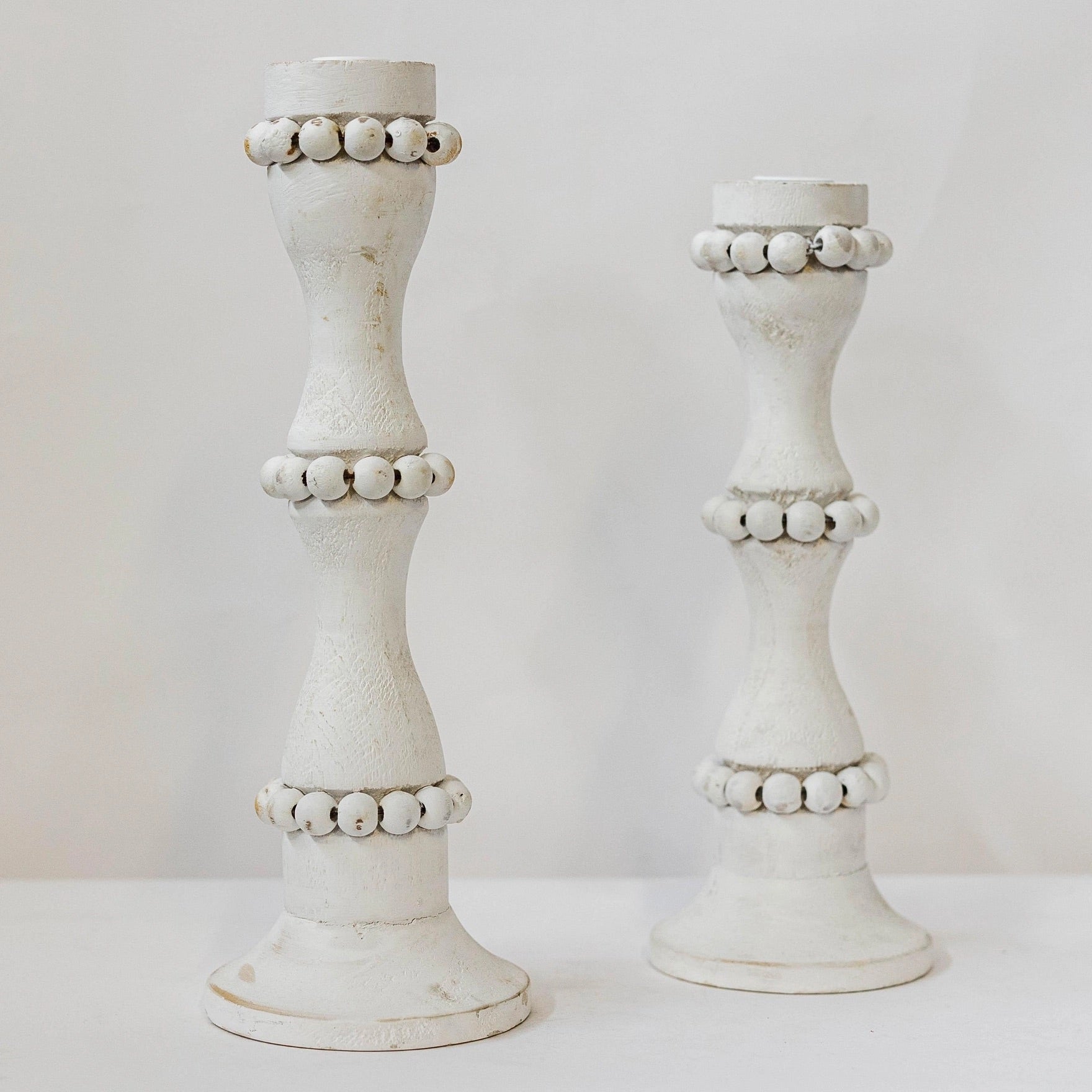 White wooden candle holders that are perfect to use as a centerpiece or throughout the home. These tall candlestick holders are perfect to gift to Mom for Mothers Day