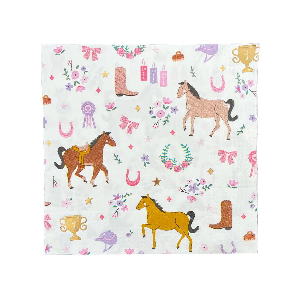 Detail shot of a pastel pony print napkin under a pink-striped boot napkin, alongside a wooden fork with a lavender-painted handle, all set against a table sprinkled with pink and lavender confetti and a tiny disco ball.