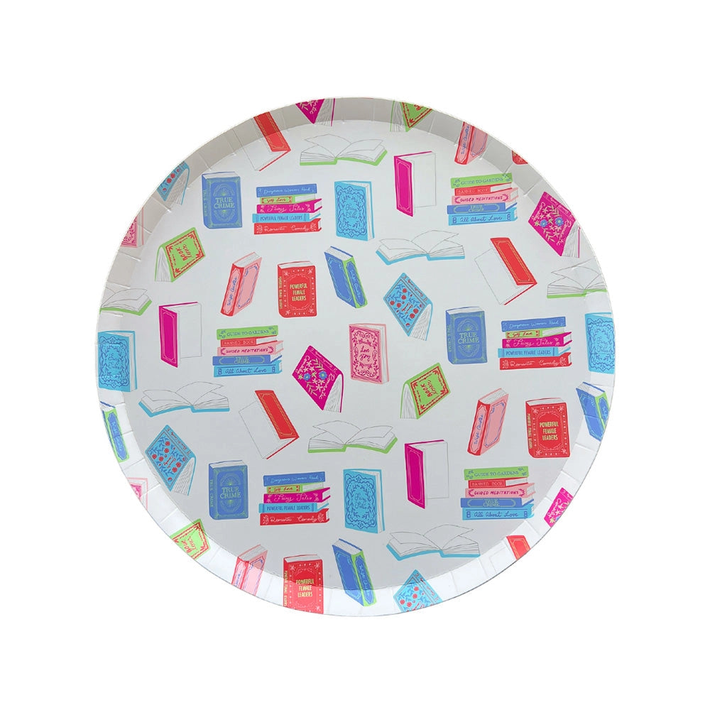 Overhead of single dessert plate showing multicolor illustrated books on white background.