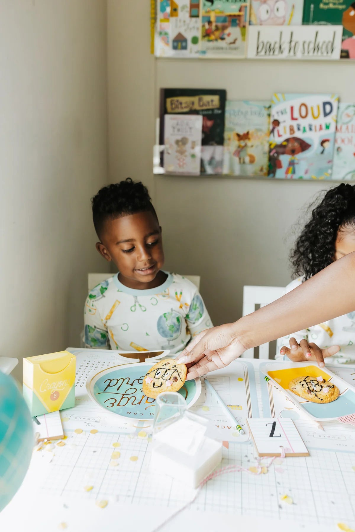 Boy enjoying cookies at a school-themed table with the planner placemat as a placemat.