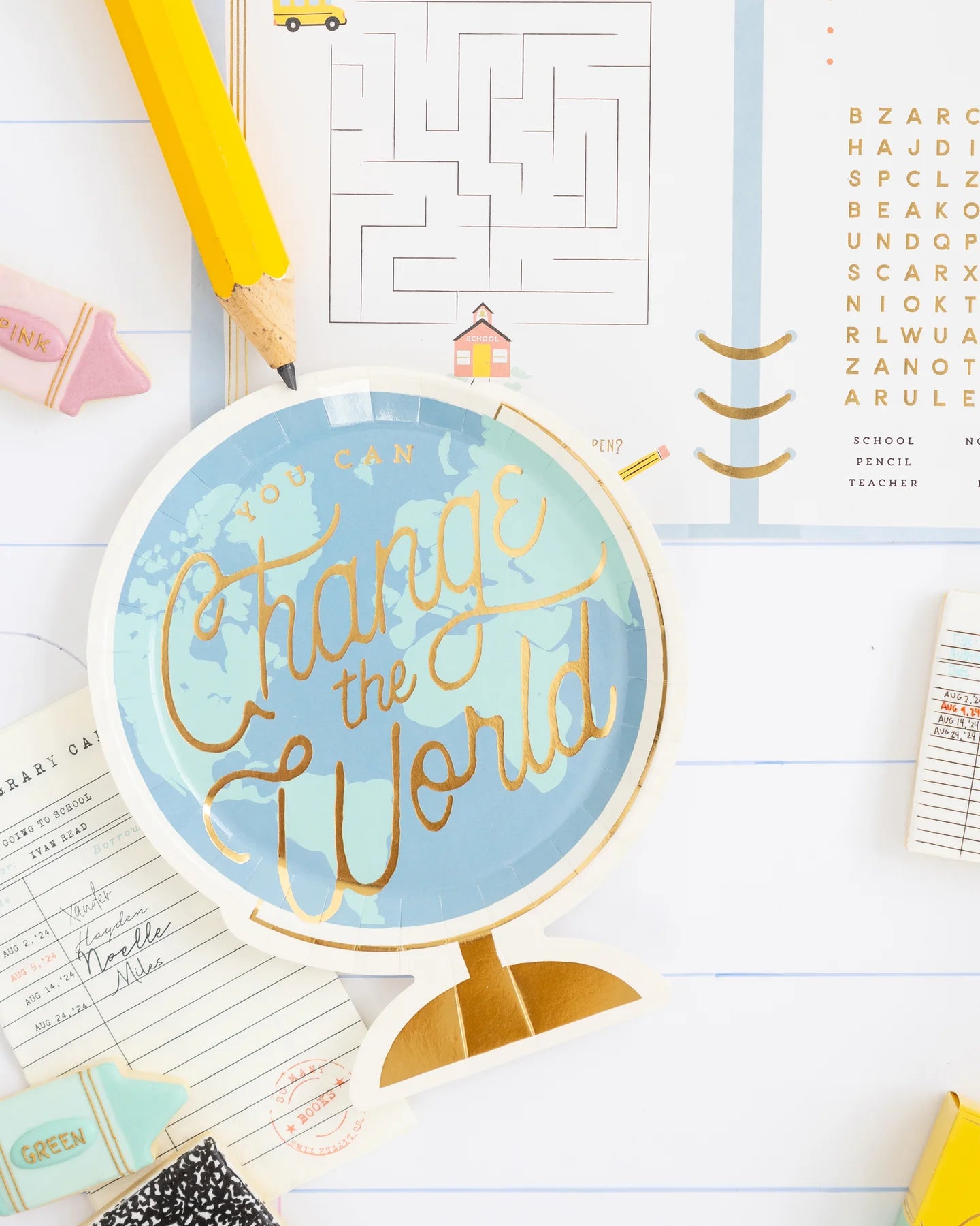 Close-up showing a “Change the World” globe plate on top of the planner placemat.