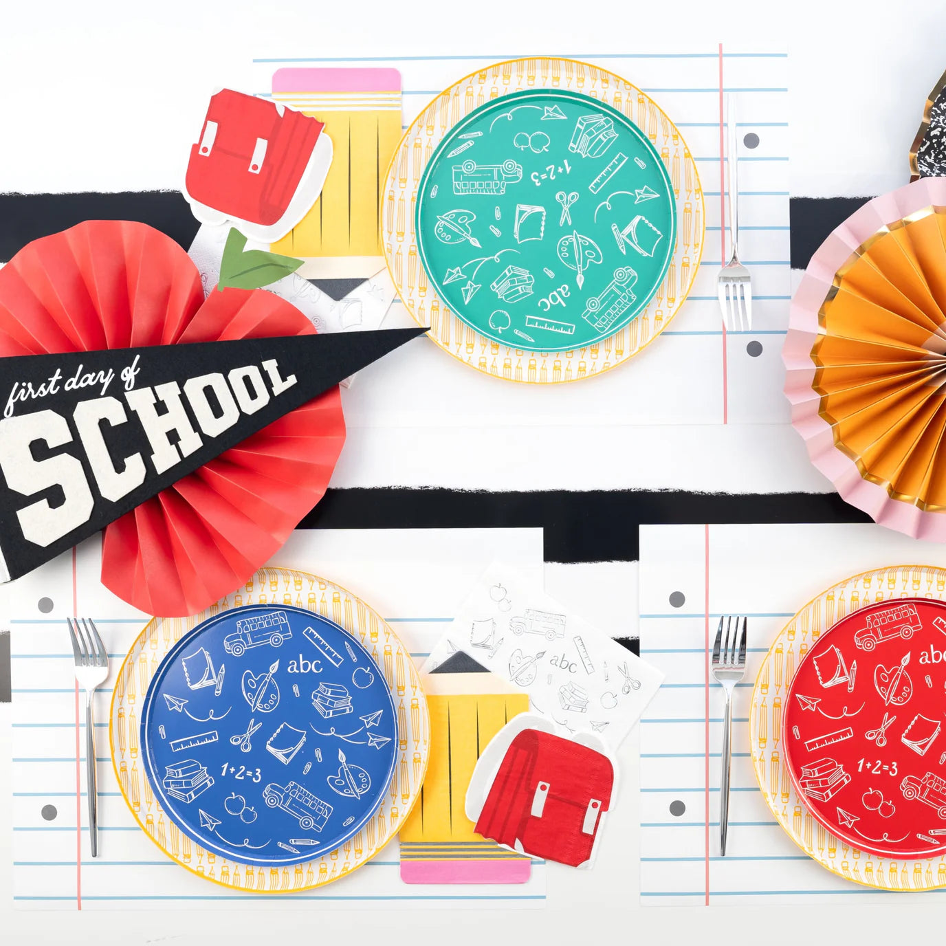 Overhead table with colorful school‑icon plates.
