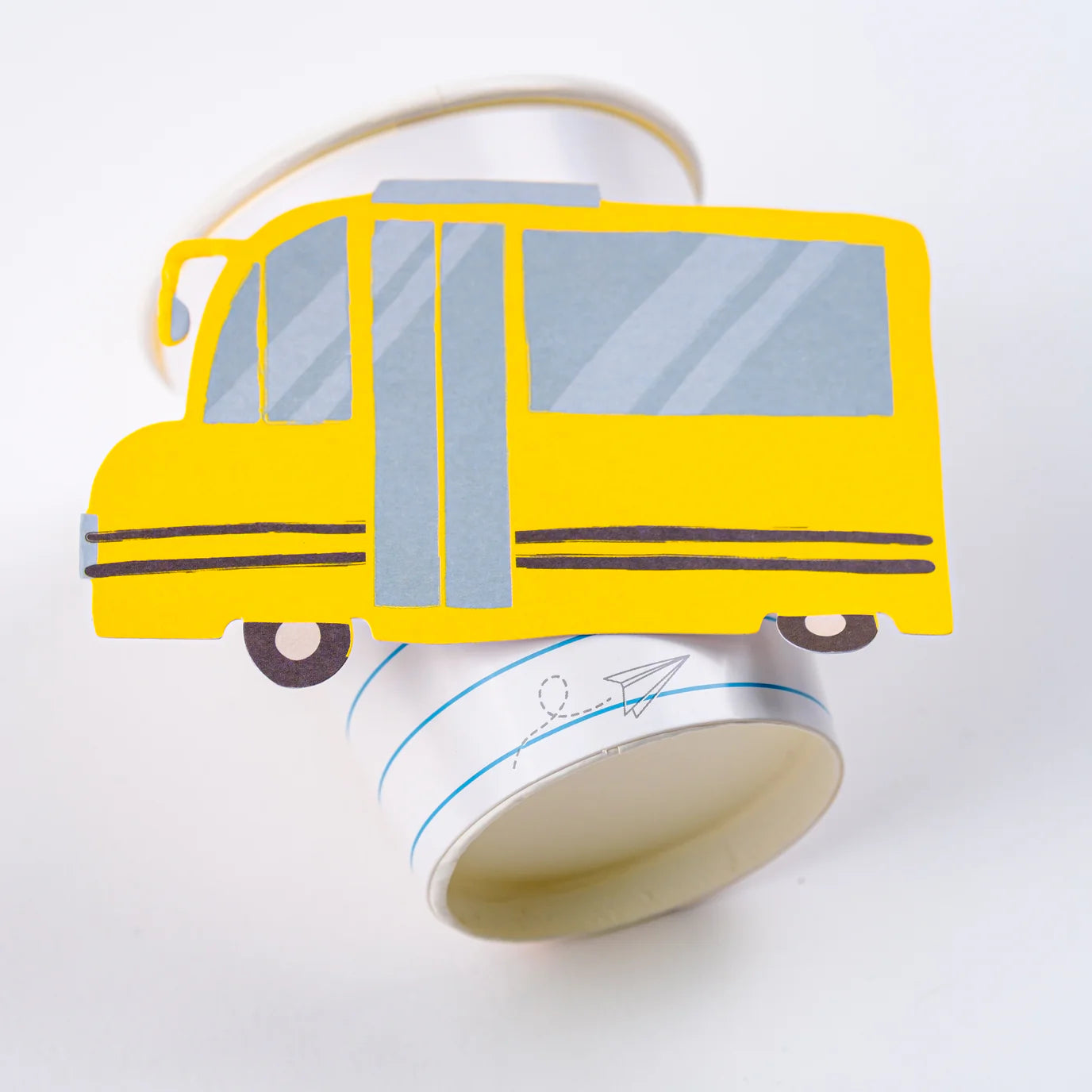 Isolated side view of assembled yellow school‑bus cup on white background.