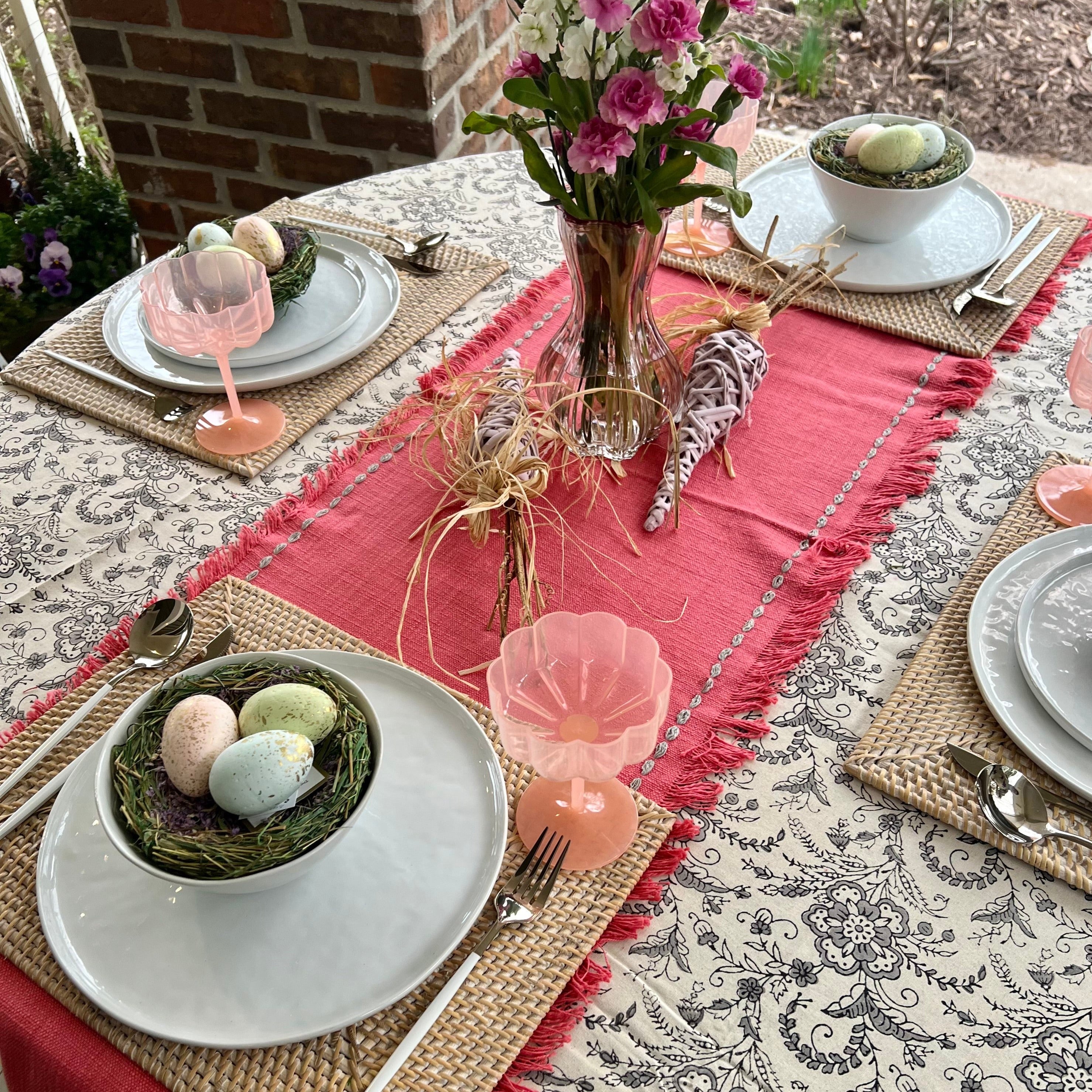 Off-white tablecloth with a gray floral design set with a Spring tablescape.
