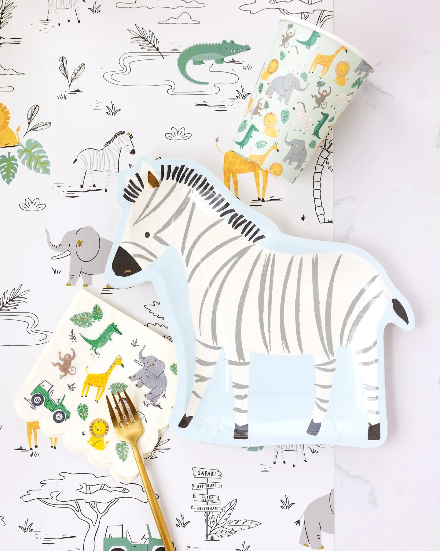 Zebra-shaped party plate displayed alongside matching napkins and cups, perfect for jungle-themed celebrations.