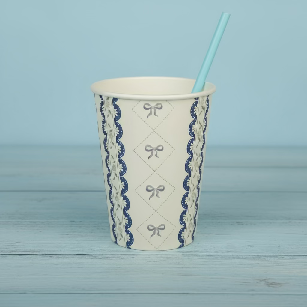 Blue coquette cup with a blue paper straw on a light wood background