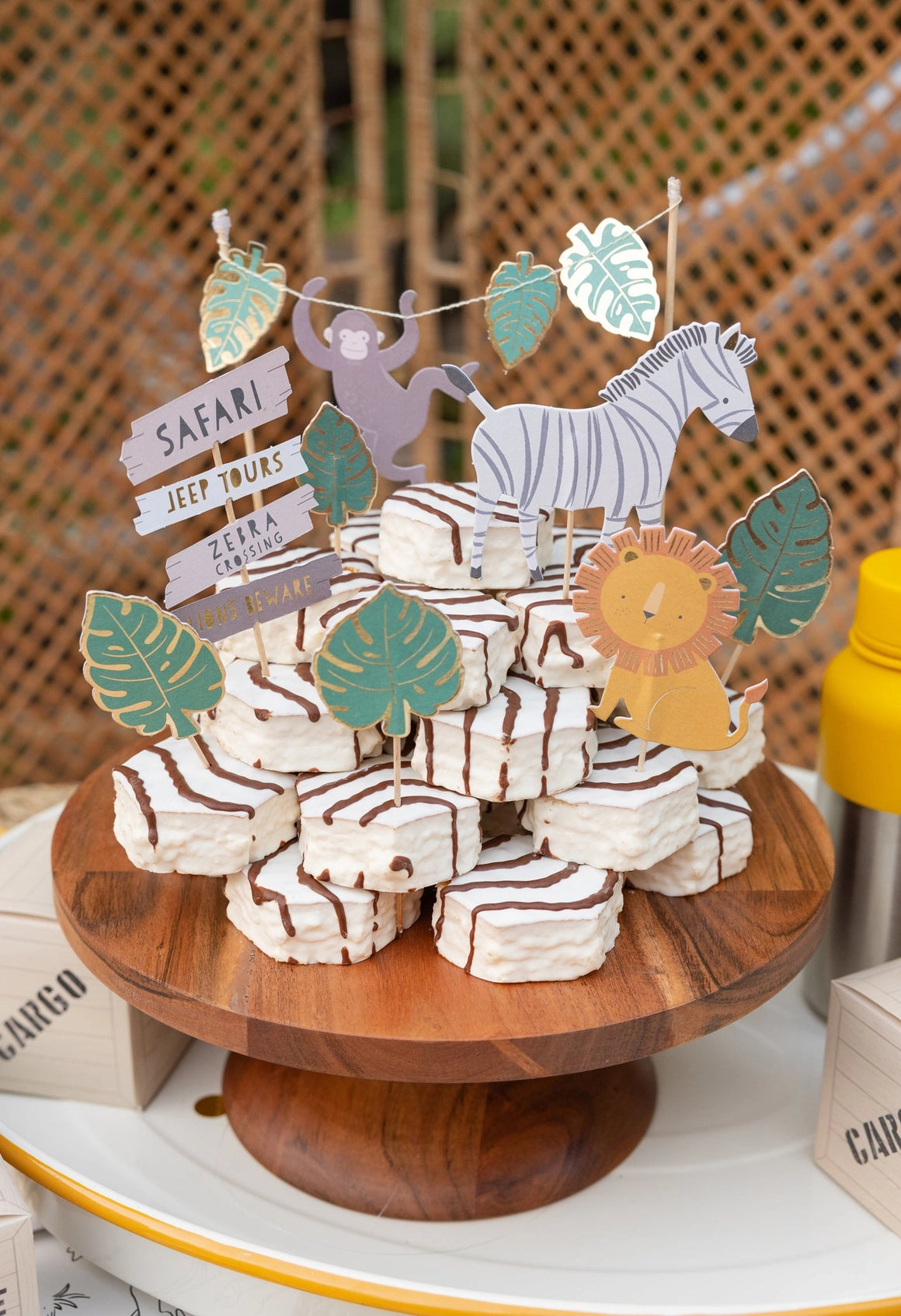 Another angle of jungle-themed animal cake toppers on a dessert display at a kids' birthday party.