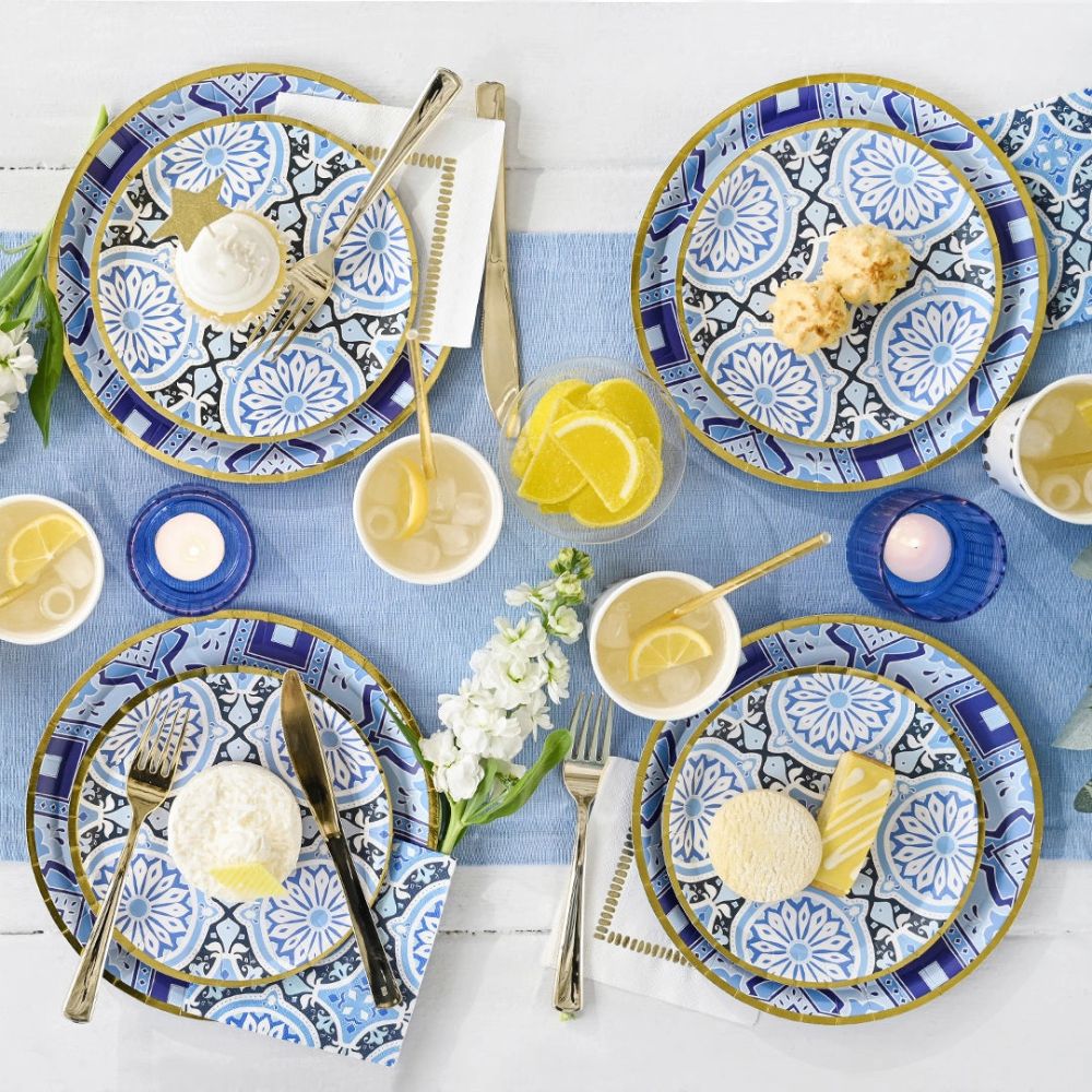 Mediterranean party table with blue tile dessert plates and summer drinks.
