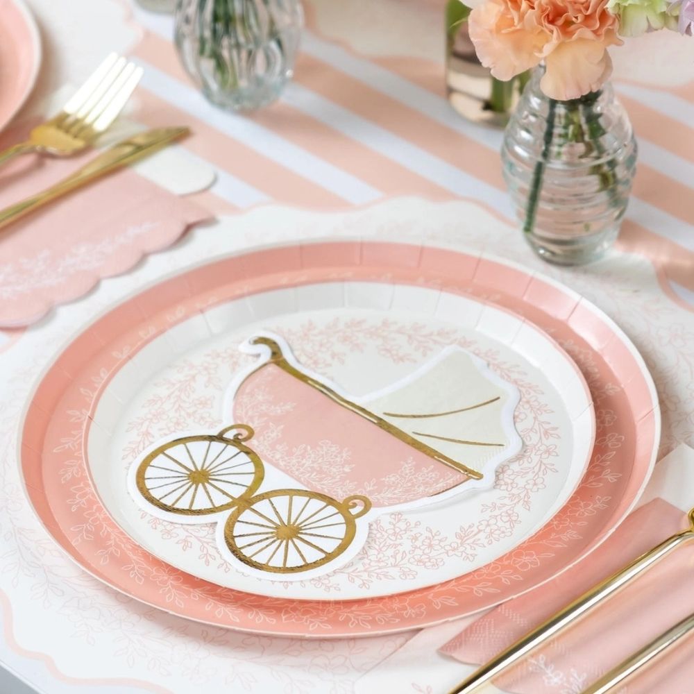 Pink dinner plate styled for baby shower table setup
