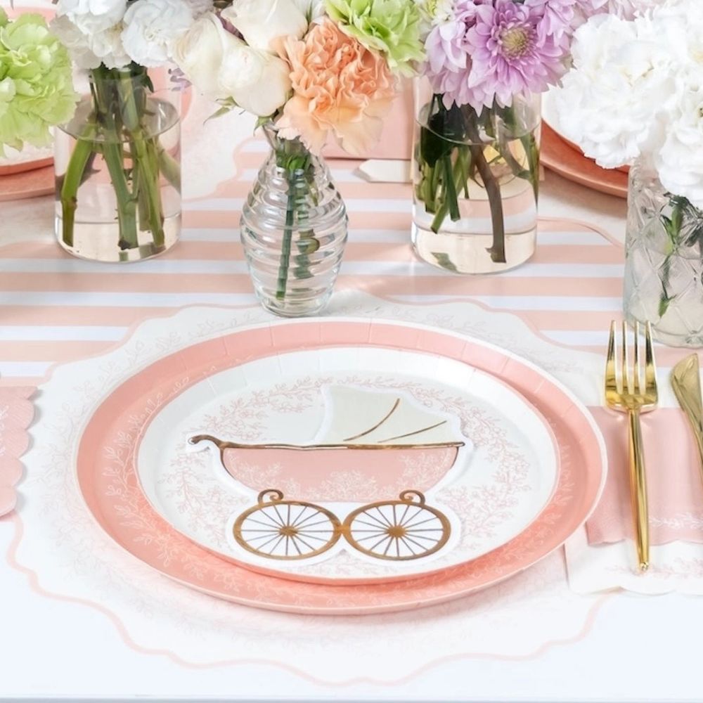 Pink dinner plate styled for baby shower table setup