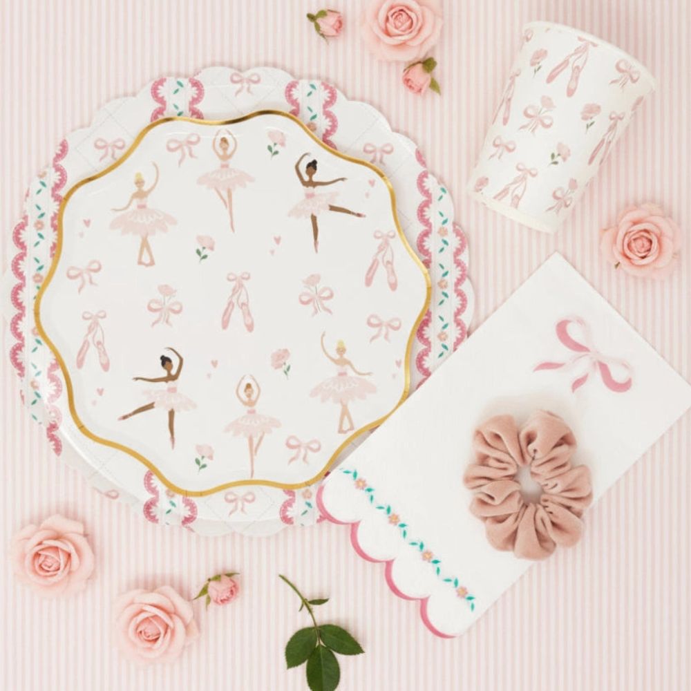 Flat lay of ballerina partyware with pink roses and striped background