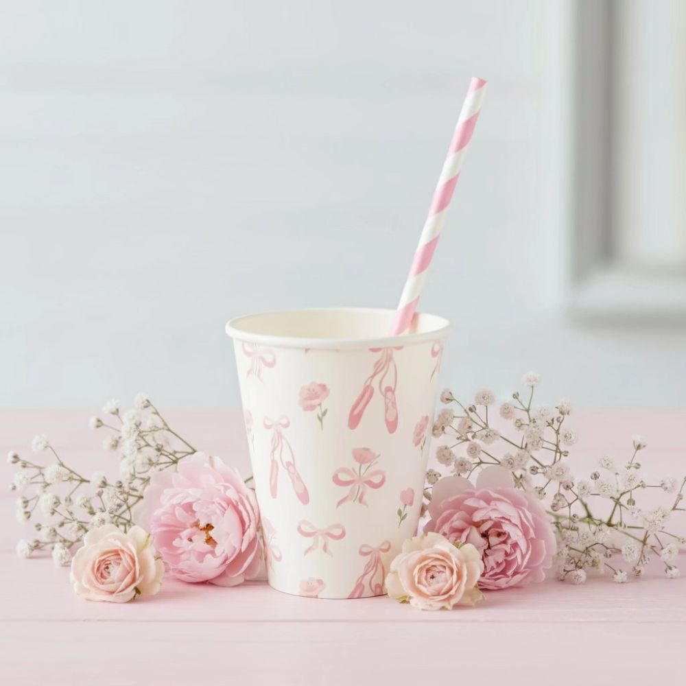Ballerina cup on a pink table with a striped straw and fresh roses