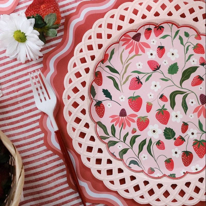 Close-up of a Strawberry Paper Plate layered on a pink lattice charger for a Berry Sweet 1st Birthday Aesthetic.