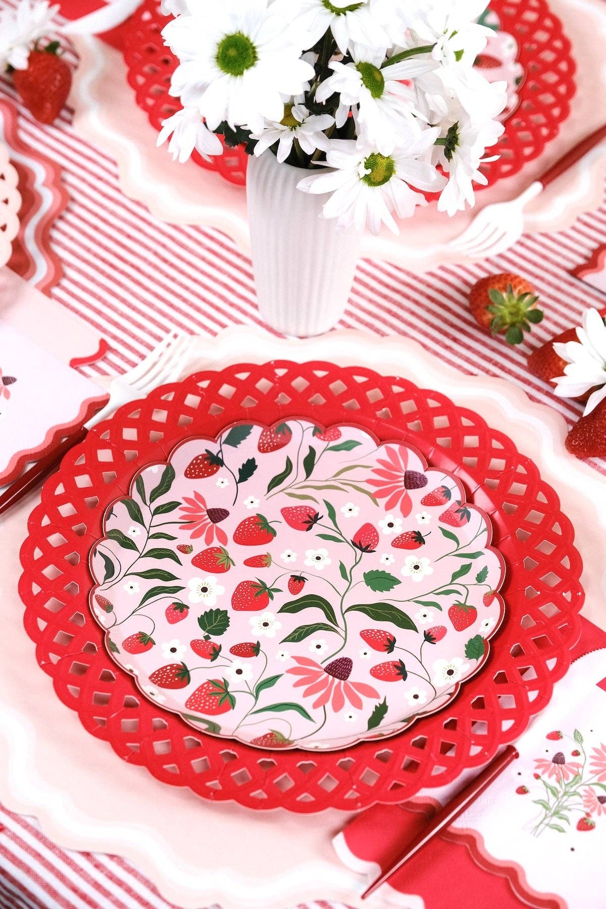Strawberry Paper Plates arranged with fresh daisies and strawberries for a Berry First Birthday celebration.