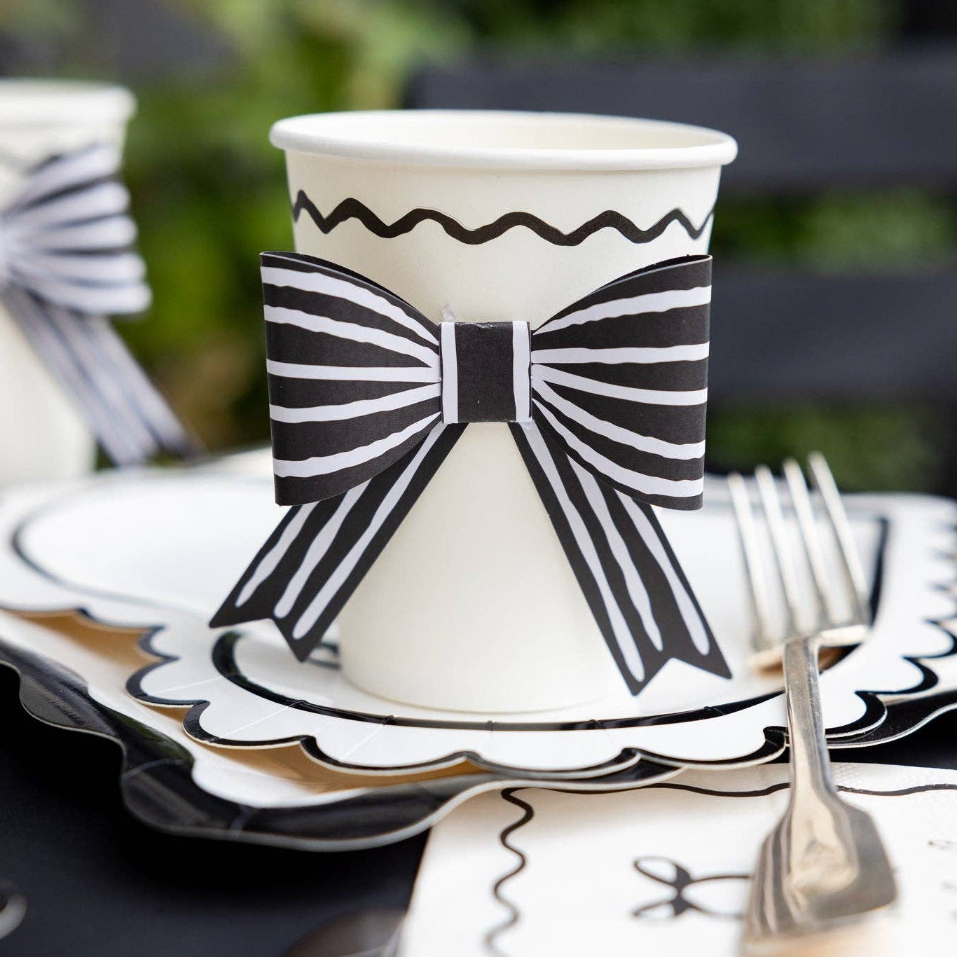 Close-up of a black and white bow party cup paired with coordinating Valentine tableware