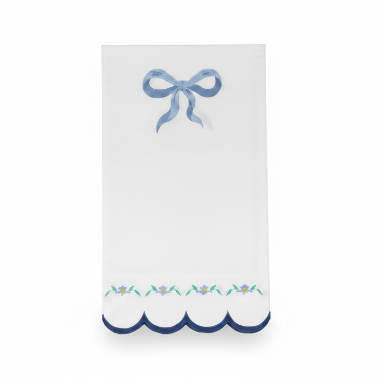 Single white luncheon napkin with a blue bow and scalloped floral edge