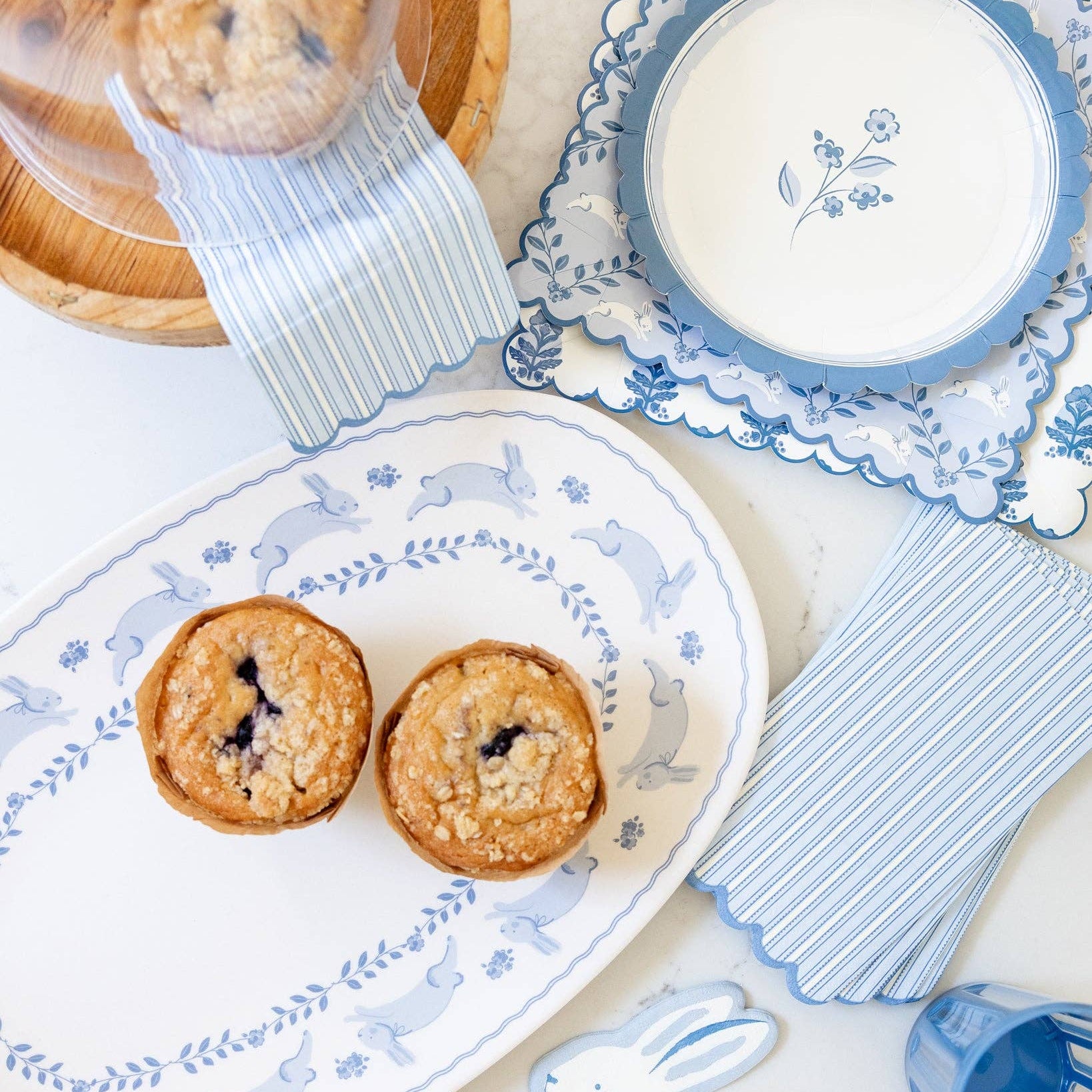 Blue bunny patterned square plates styled with Easter table setting and baked goods