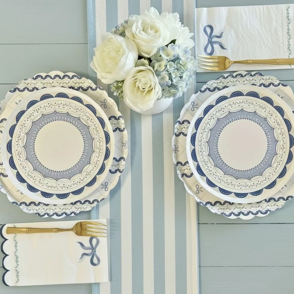 Layered place setting with a large blue bow plate, small lace plate, and matching cup