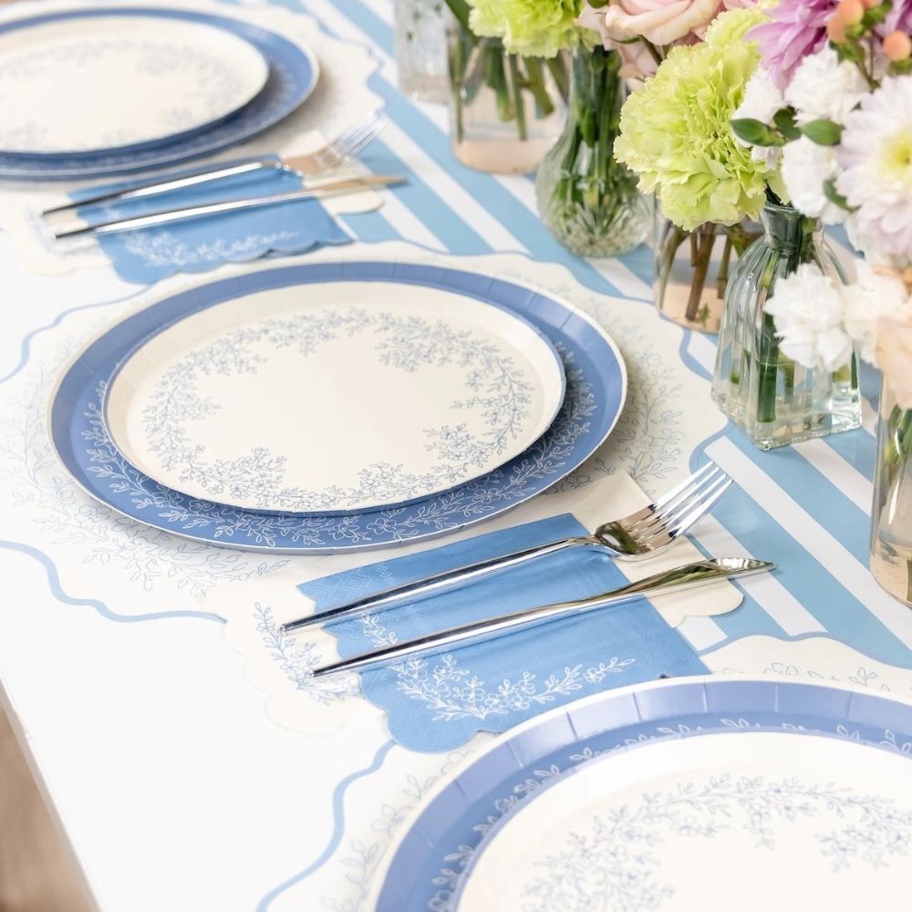 blue floral placemat under place setting with silverware and napkin.