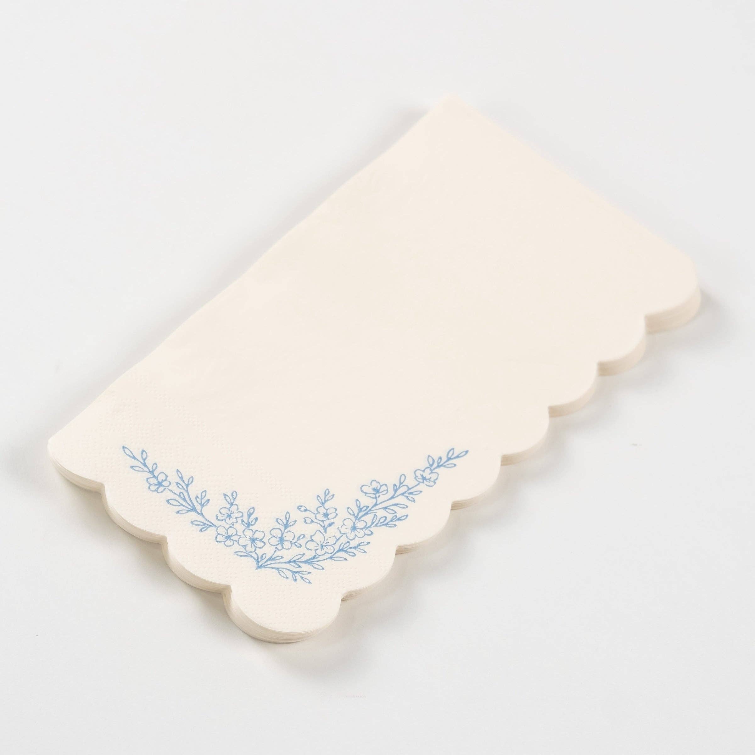Stacked blue floral guest towels with scalloped edges and floral print.
