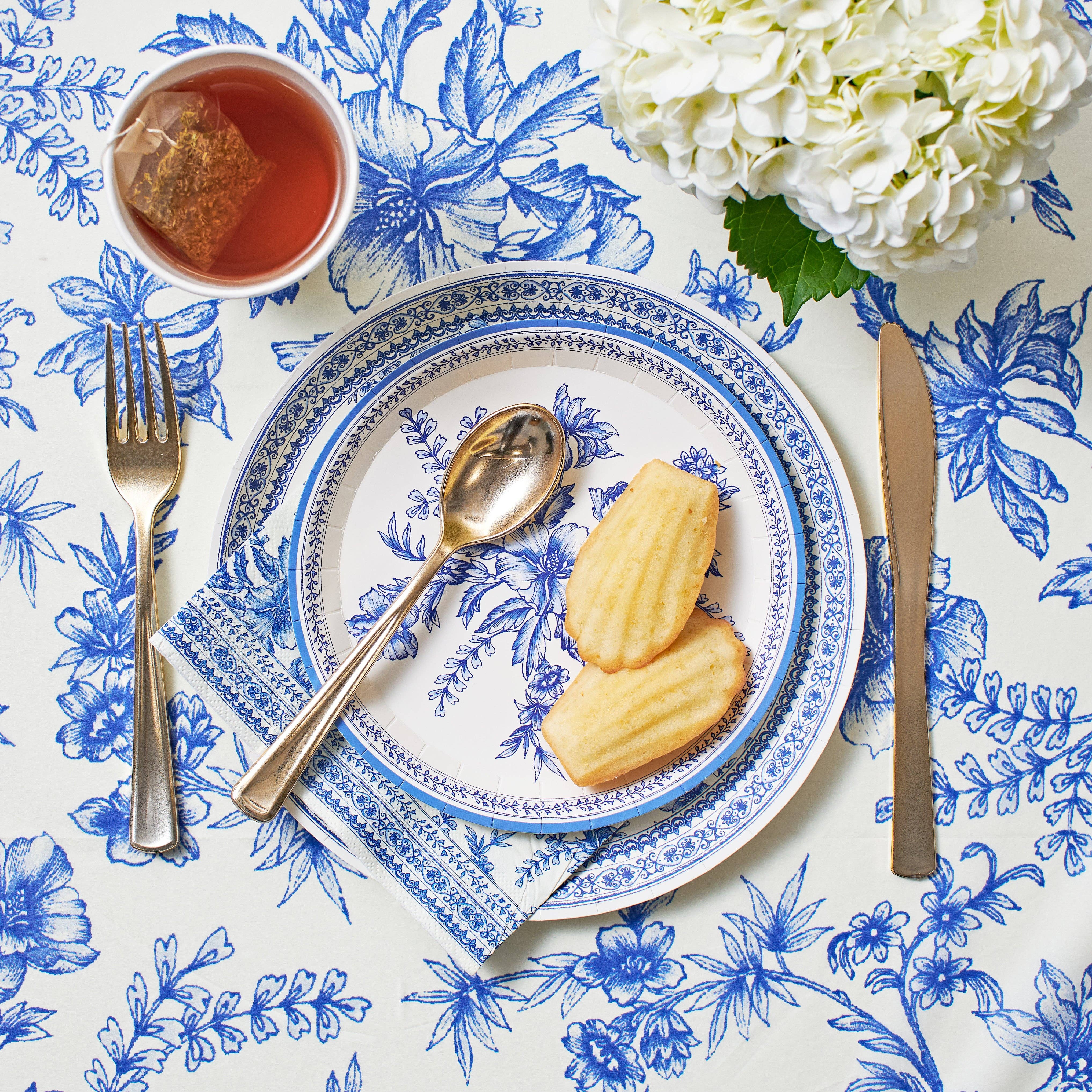 Blue toile napkins styled with tea, pastries, and place setting