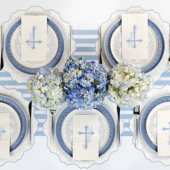An angled close up of a white guest towel featuring a light blue cross and Heirloom Watercolor floral sprigs.
