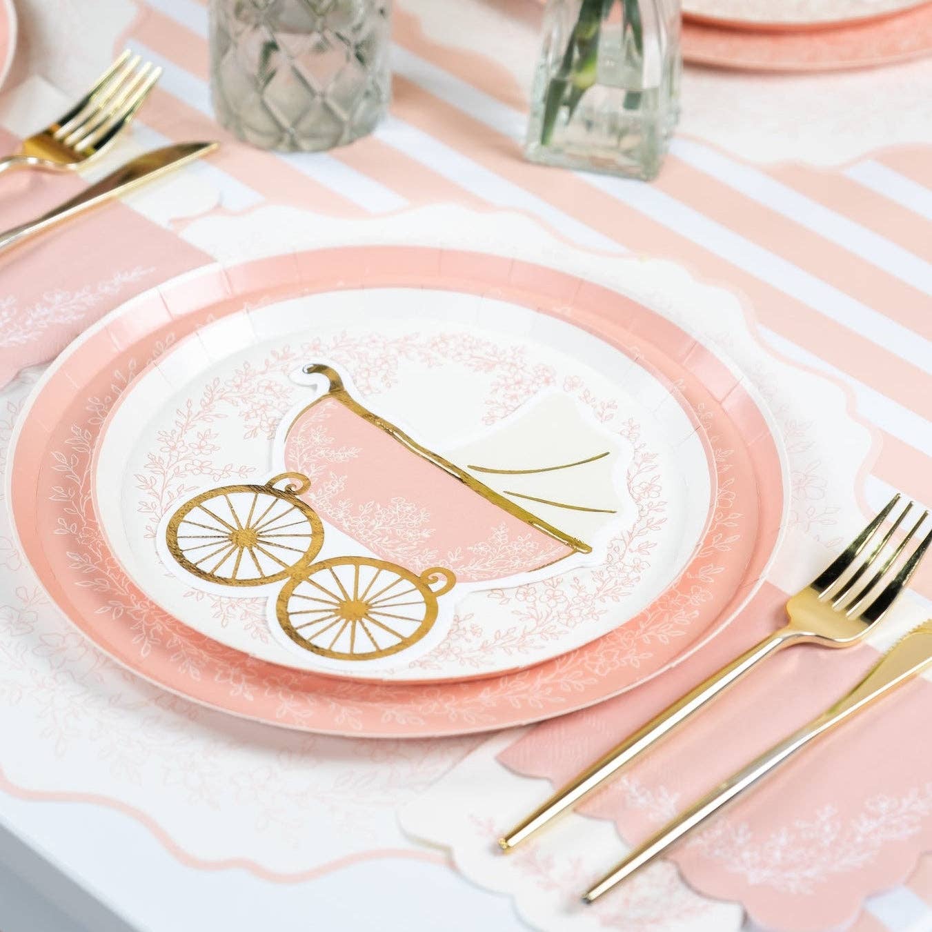 Layered place setting with a pink placemat under a matching carriage themed plate
