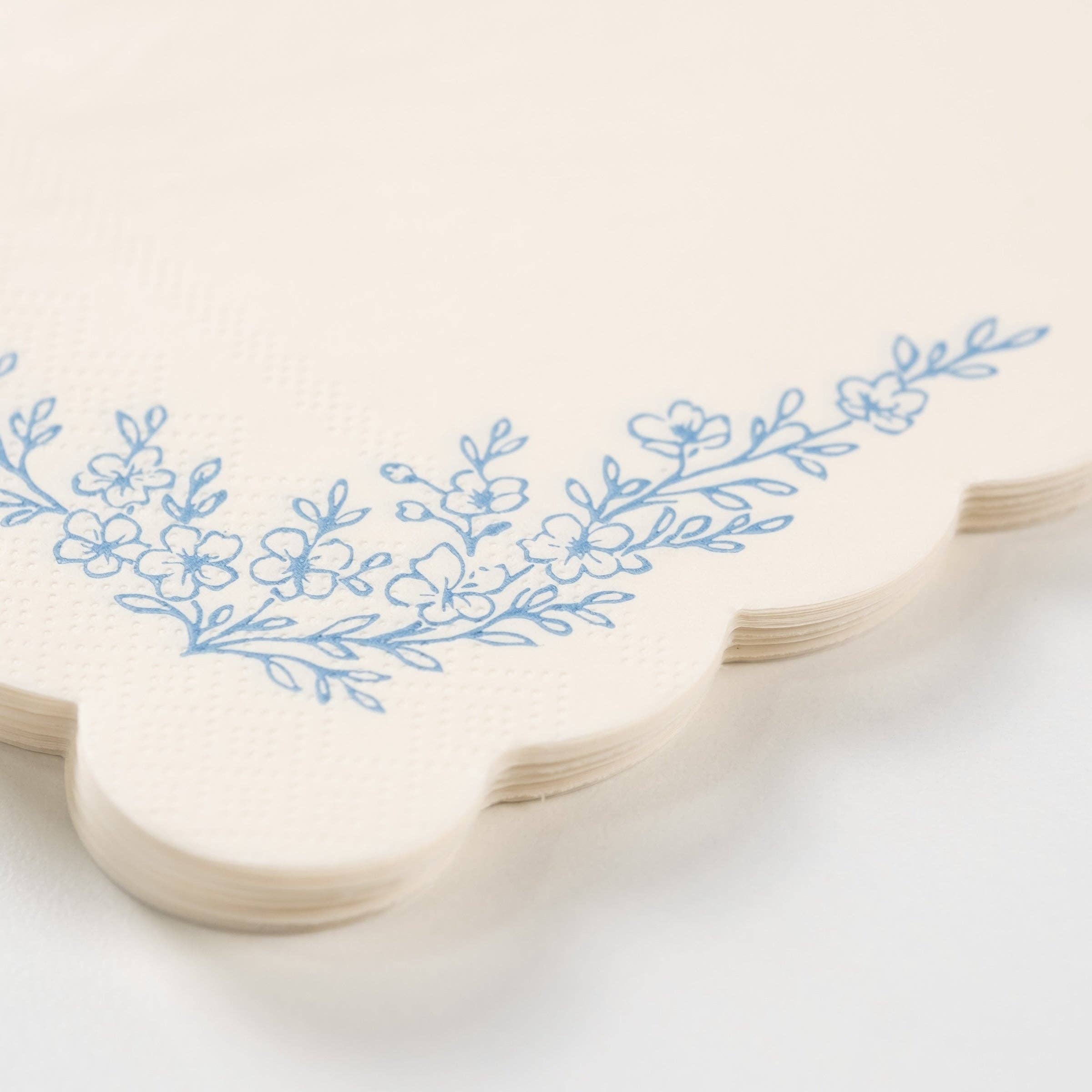 Close-up of dusty blue guest towel showing floral corner detail.
