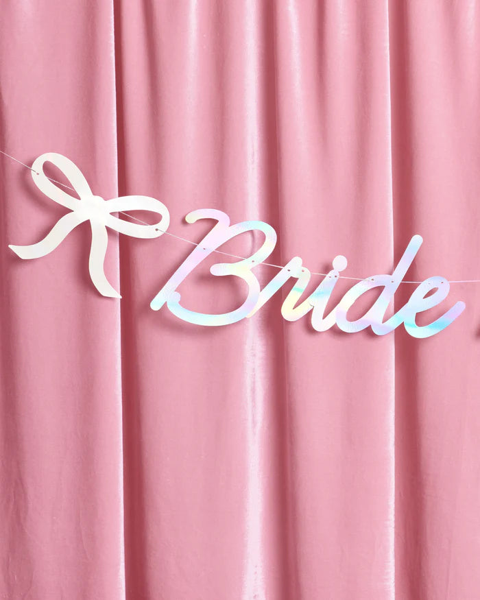 Detail of Bride to Be iridescent banner bow icon and script on pink velvet backdrop