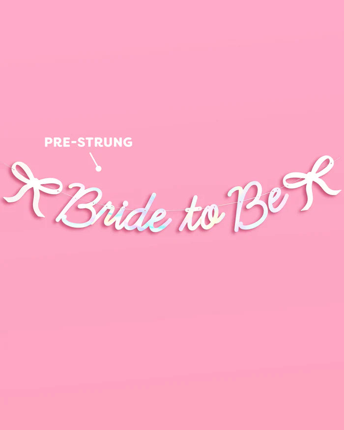 Bride to Be iridescent foil banner with bow accents pre-strung and displayed on pink background