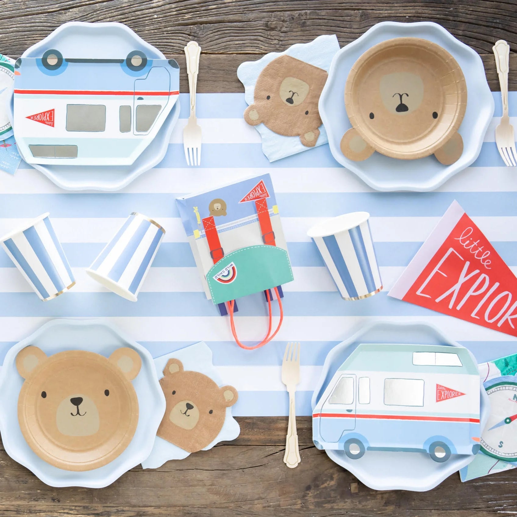 Kids’ camping‑themed party table featuring bear plates and a sky‑blue cabana stripe paper table runner.