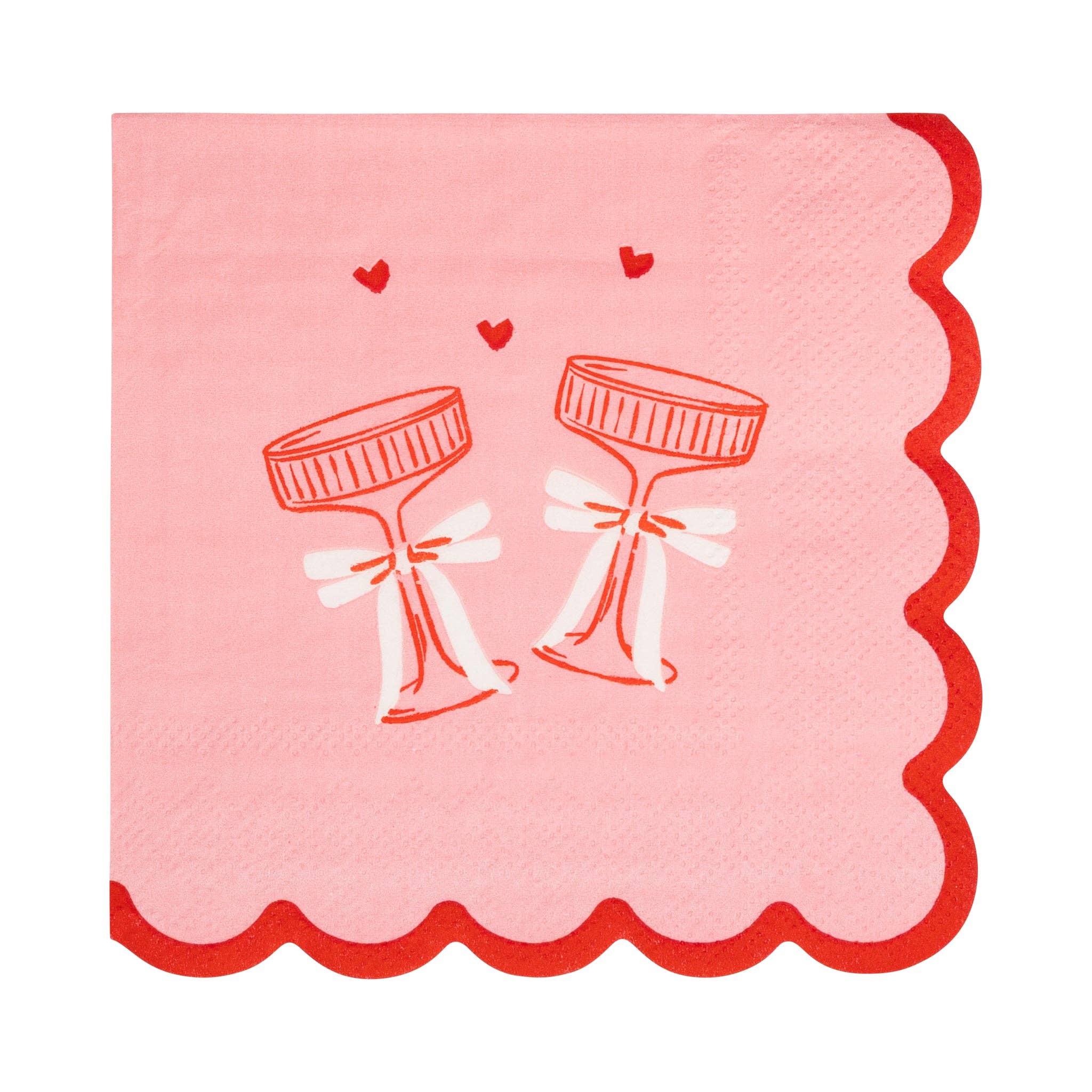 This image shows a pink cocktail napkin with red scalloped edges and an illustration of two clinking coupe glasses tied with bows.
