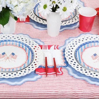 A Grandmillennial July 4th Decor table featuring flag plates and white scalloped chargers.
