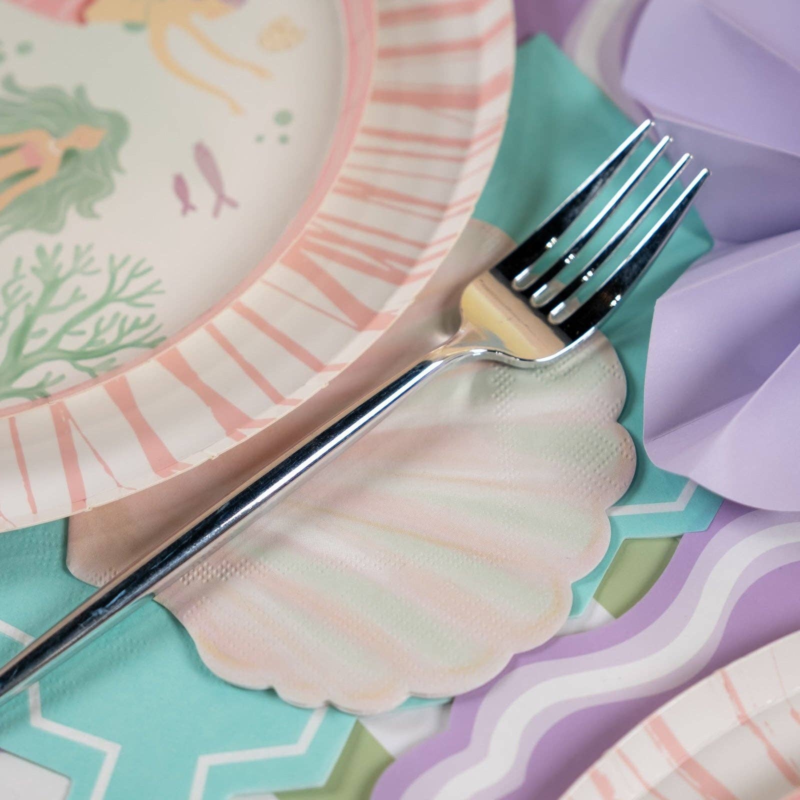 coastal napkins styled with fork and mermaid themed decor.