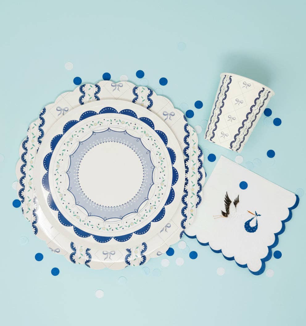 Blue bow themed place setting with a stork napkin and blue confetti
